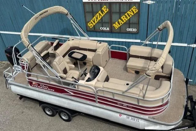 The Image of 2019 Sun Tracker SportFish 22 DLX pontoon boat with beige seating and canopy, displayed at Sizzle Marine. - 0
