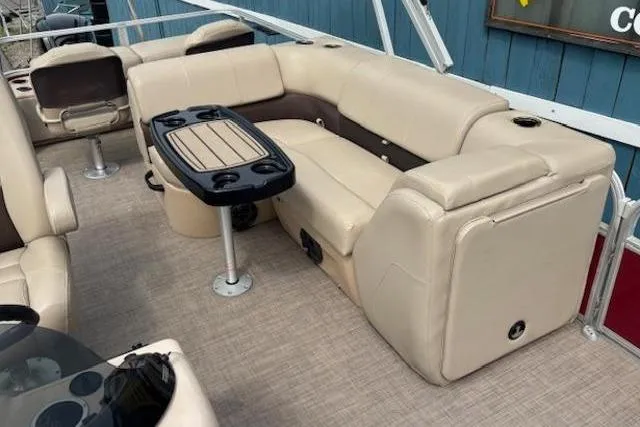 Slide: The Image of 2019 Sun Tracker SportFish 22 DLX pontoon boat with beige seating and table. - 16