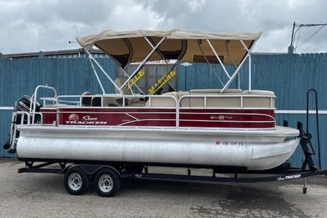 Slide: The Image of 2019 Sun Tracker SportFish 22 DLX pontoon boat with canopy on trailer. - 2