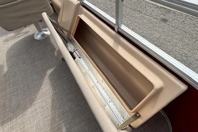 Slide: The Image of 2019 Sun Tracker SportFish 22 DLX boat seat storage compartment open, beige interior. - 22
