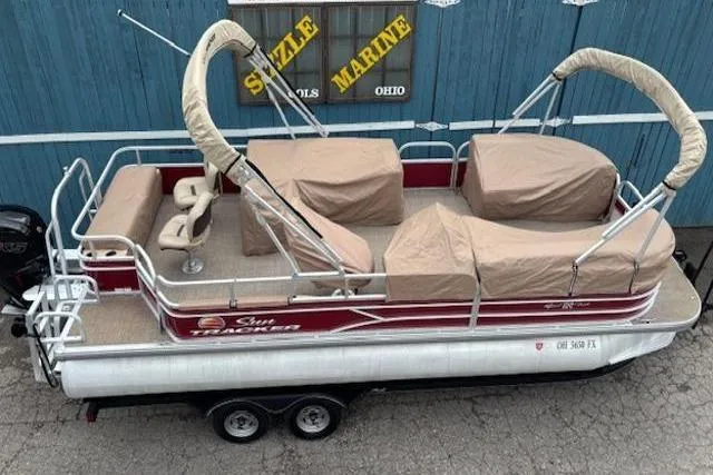 Slide: The Image of 2019 Sun Tracker SportFish 22 DLX pontoon boat with beige covers, parked on a trailer. - 27