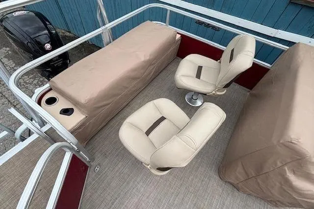 Slide: The Image of 2019 Sun Tracker SportFish 22 DLX interior with beige seating and covered storage. - 31