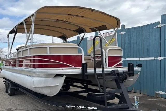 Slide: The Image of 2019 Sun Tracker SportFish 22 DLX pontoon boat on trailer, parked by blue fence. - 4