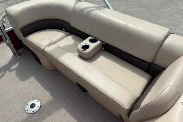 Slide: The Image of 2019 Sun Tracker SportFish 22 DLX boat interior with beige seating and cup holders. - 9