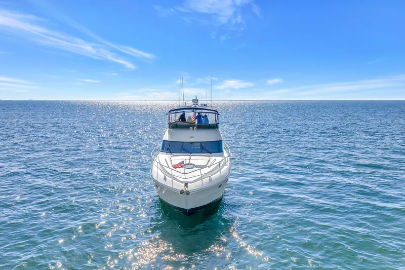 Slide: The Image of 2001 Neptunus 56 Flybridge yacht cruising on open sea under clear blue sky. - 13