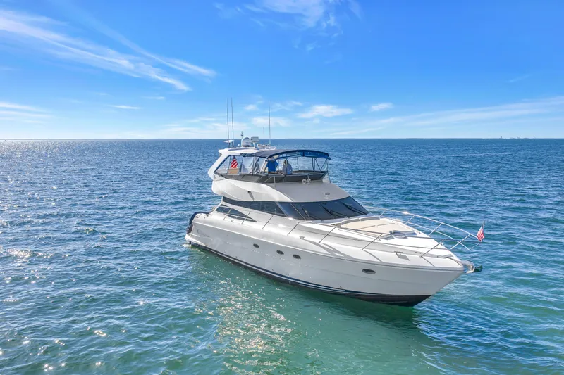 Slide: The Image of 2001 Neptunus 56 Flybridge yacht cruising on open sea under clear blue sky. - 14