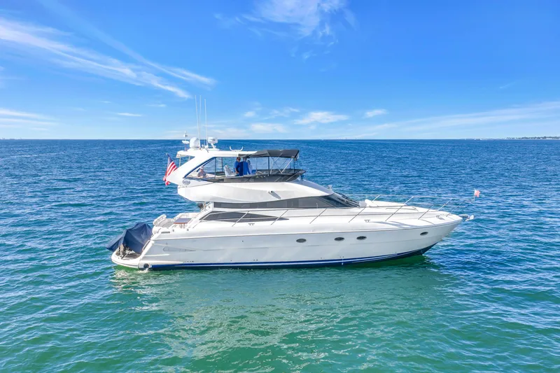 Slide: The Image of 2001 Neptunus 56 Flybridge yacht cruising on open blue sea under clear sky. - 15