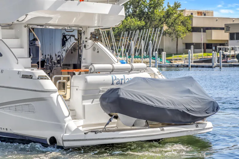 Slide: The Image of 2001 Neptunus 56 Flybridge yacht docked with covered tender at marina. - 16