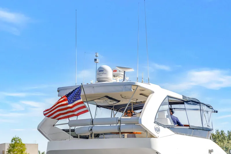 Slide: The Image of 2001 Neptunus 56 Flybridge yacht with American flag, cruising under clear blue skies. - 17