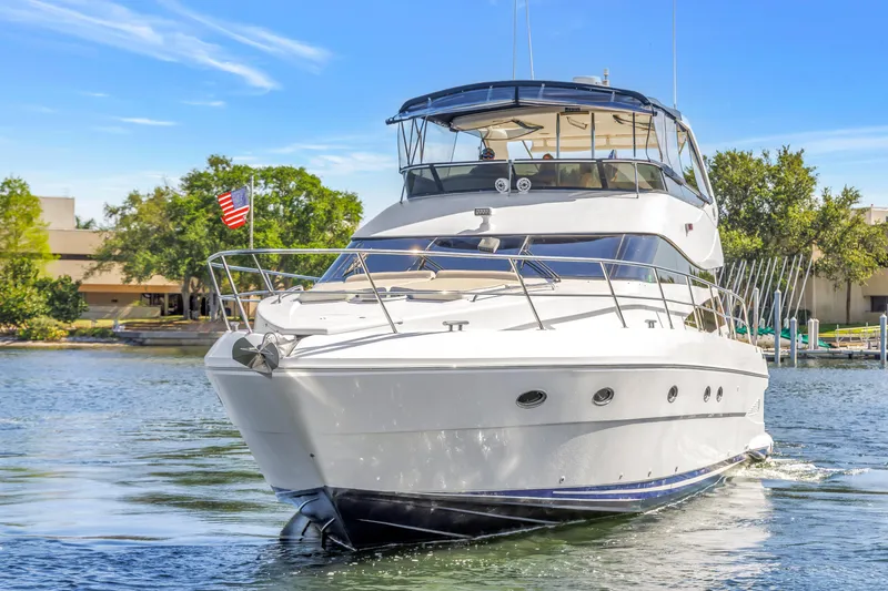 Slide: The Image of 2001 Neptunus 56 Flybridge yacht cruising on a sunny day, American flag visible. - 19