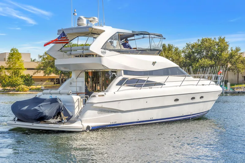 Slide: The Image of 2001 Neptunus 56 Flybridge yacht cruising on a sunny day near a marina. - 2