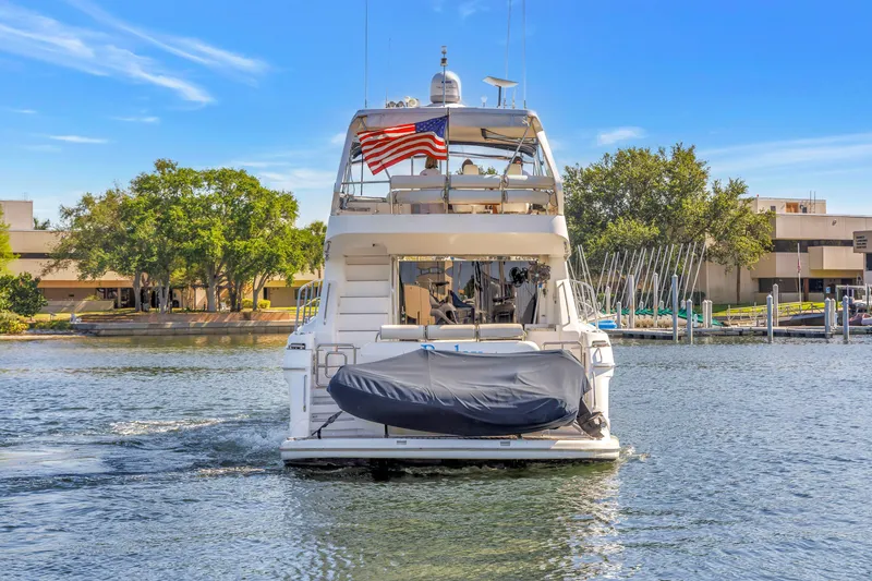 Slide: The Image of 2001 Neptunus 56 Flybridge yacht with American flag, docked in a marina. - 22