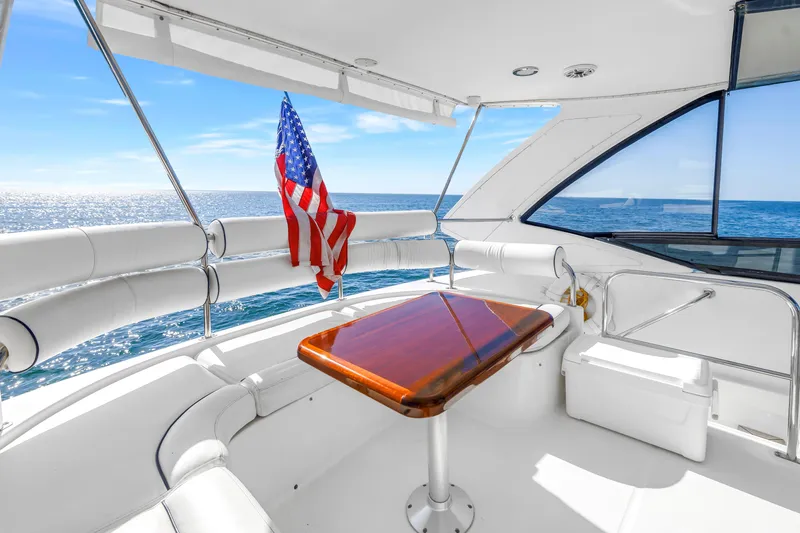 Slide: The Image of Luxurious Neptunus 56 Flybridge yacht interior with ocean view, featuring a polished wooden table. - 29