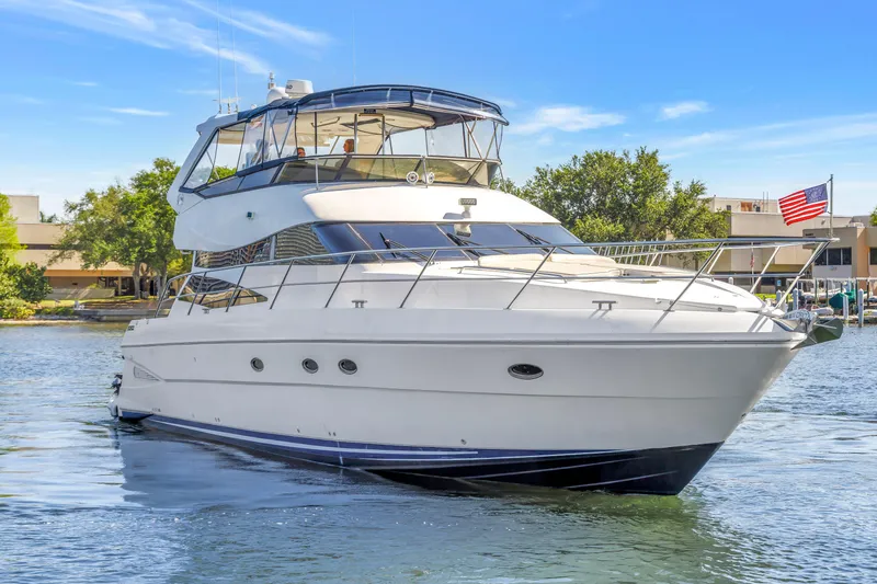 Slide: The Image of 2001 Neptunus 56 Flybridge yacht cruising on a sunny day, American flag visible. - 4