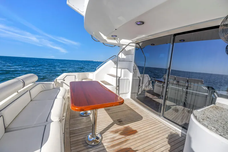 Slide: The Image of Luxurious Neptunus 56 Flybridge yacht deck with ocean view, featuring elegant seating and table. - 40