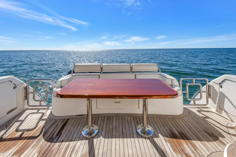 Slide: The Image of Flybridge deck of 2001 Neptunus 56 yacht with ocean view and wooden table. - 42