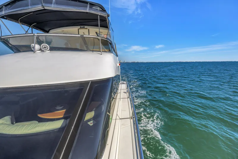 Slide: The Image of 2001 Neptunus 56 Flybridge yacht cruising on open sea under clear blue sky. - 45