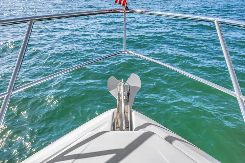 Slide: The Image of Bow view of 2001 Neptunus 56 Flybridge yacht on clear blue water. - 48