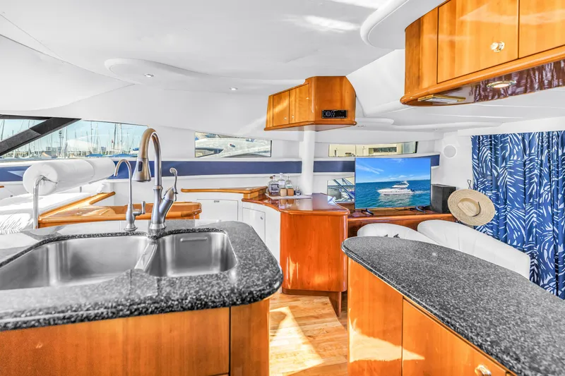 Slide: The Image of Luxurious interior of 2001 Neptunus 56 Flybridge yacht with modern kitchen and seating area. - 58