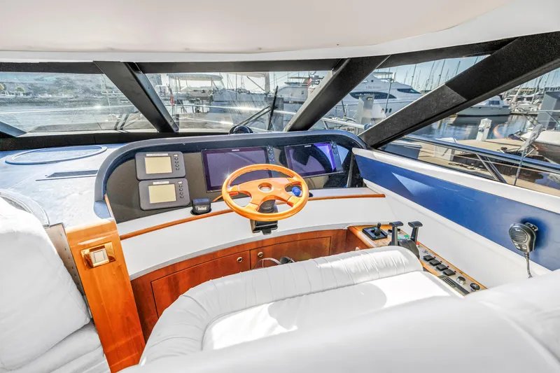 Slide: The Image of Helm of 2001 Neptunus 56 Flybridge yacht with modern controls and wooden steering wheel. - 64