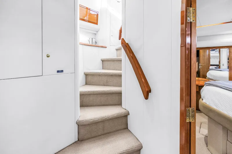 Slide: The Image of Interior staircase of 2001 Neptunus 56 Flybridge yacht, featuring elegant wood accents and plush carpeting. - 68