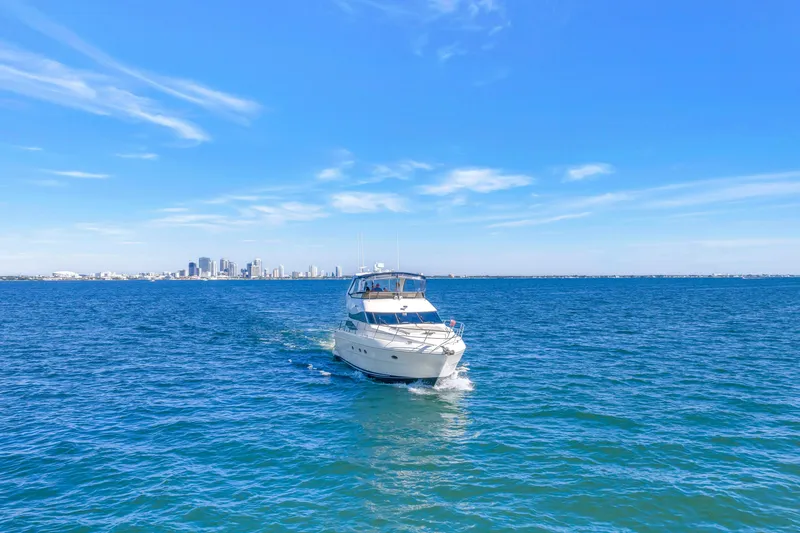 Slide: The Image of 2001 Neptunus 56 Flybridge yacht cruising on open water with city skyline in background. - 8