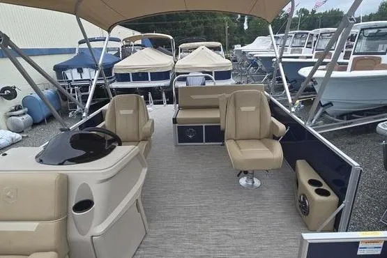 Slide: The Image of 2026 Godfrey Xperience 2286 pontoon boat with beige seating and canopy in a marina. - 5