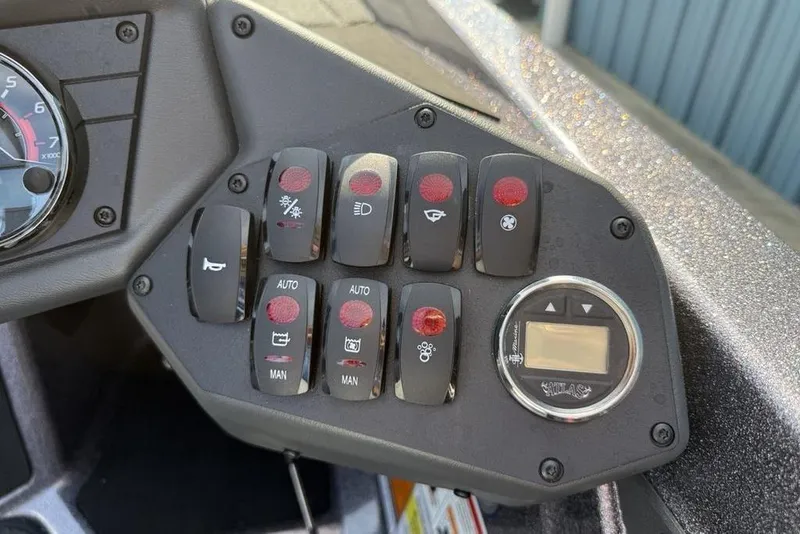 Slide: The Image of Control panel of a 2026 Skeeter ZXE20 boat with various switches and a digital display. - 22
