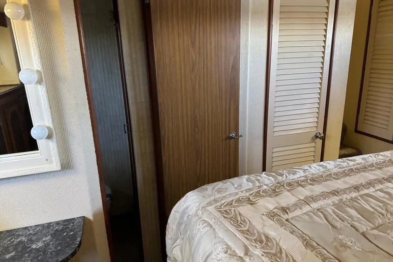 Slide: The Image of 1978 Viking 43 Aft Cabin interior with bed, mirror, and wooden doors. - 13