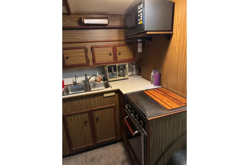 Slide: The Image of 1978 Viking 43 Aft Cabin kitchen with wood cabinets and modern appliances. - 7