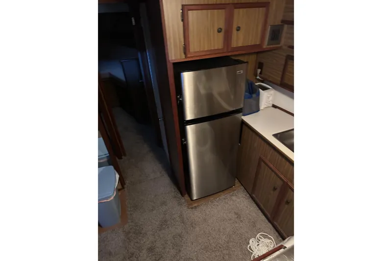 Slide: The Image of 1978 Viking 43 Aft Cabin interior with stainless steel fridge and wooden cabinetry. - 8