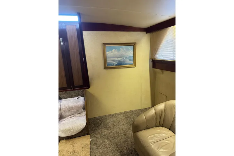 Slide: The Image of 1978 Viking 43 Aft Cabin interior with painting, beige chair, and wooden accents. - 9