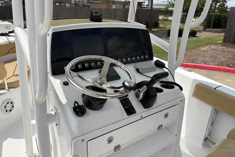 Slide: The Image of 2021 Sportsman Heritage 211 Center Console boat dashboard with steering wheel and controls. - 10