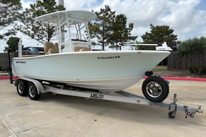 Slide: The Image of 2021 Sportsman Heritage 211 Center Console boat on trailer, parked outdoors. - 2