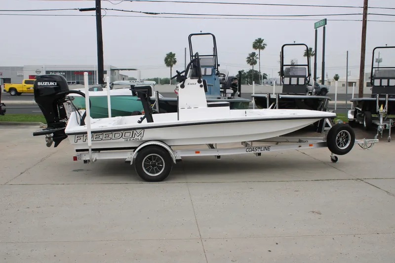 Slide: The Image of 2026 Freedom Boats 16' Eagle on trailer, featuring Suzuki outboard motor, parked outdoors. - 12