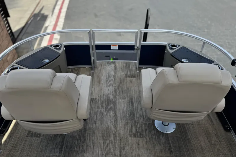 Slide: The Image of 2024 Ranger Reata 223F boat interior with two beige seats and wood-style flooring. - 10