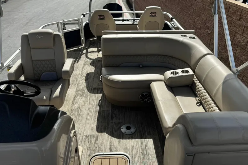 Slide: The Image of 2024 Ranger Reata 223F boat interior with beige seating and wood-style flooring. - 16