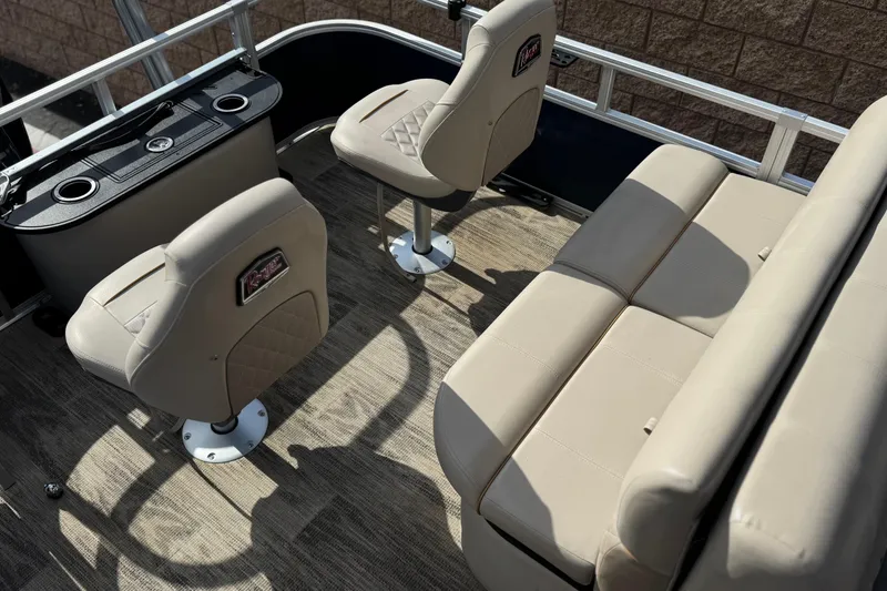 Slide: The Image of 2024 Ranger Reata 223F boat interior with beige seating and console, showcasing luxury design. - 19