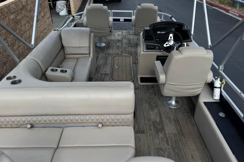 Slide: The Image of 2024 Ranger Reata 223F boat interior with beige seating and modern steering console. - 26