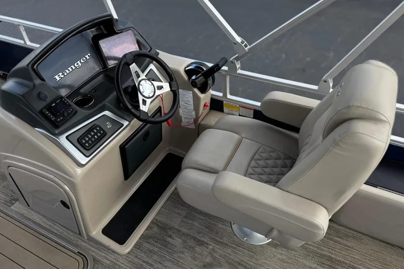 Slide: The Image of 2024 Ranger Reata 223F boat cockpit with steering wheel and comfortable captain's chair. - 28