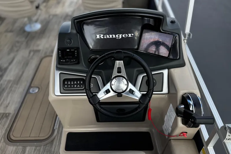 Slide: The Image of 2024 Ranger Reata 223F boat dashboard with steering wheel and control panel. - 29