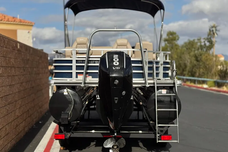 Slide: The Image of 2024 Ranger Reata 223F pontoon boat with 200 V6 engine, parked outdoors. - 5