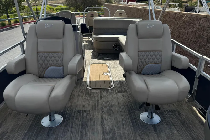 Slide: The Image of 2024 Ranger Reata 223F boat interior with plush seating and wood-style flooring. - 9