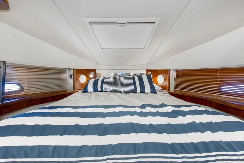 Slide: The Image of Luxurious cabin interior of 2006 Sea Ray 48 Sundancer yacht with striped bedding. - 28