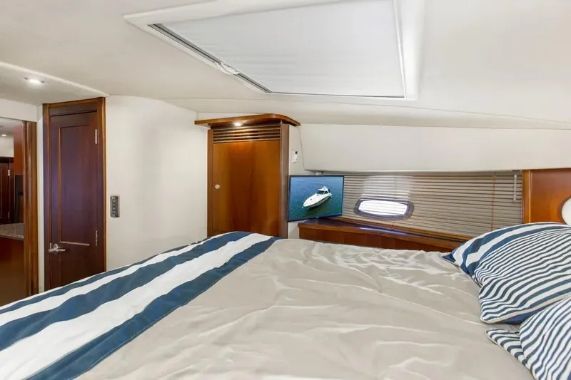 Slide: The Image of Luxurious cabin interior of 2006 Sea Ray 48 Sundancer yacht with striped bedding. - 29
