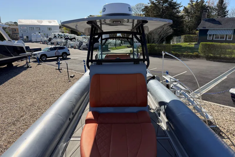 Slide: The Image of 2023 Fluid Watercraft M35 boat with orange seating, docked in a marina. - 10