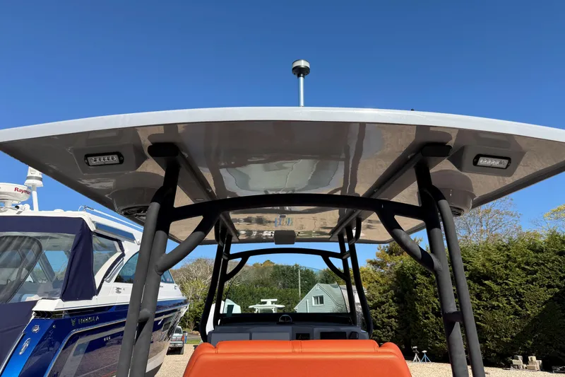 Slide: The Image of 2023 Fluid Watercraft M35 boat with canopy, docked under clear blue sky. - 6