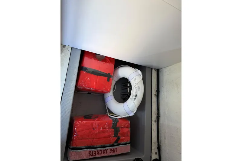 Slide: The Image of Life jackets and lifebuoy stored in a 2023 Fluid Watercraft M35 compartment. - 9