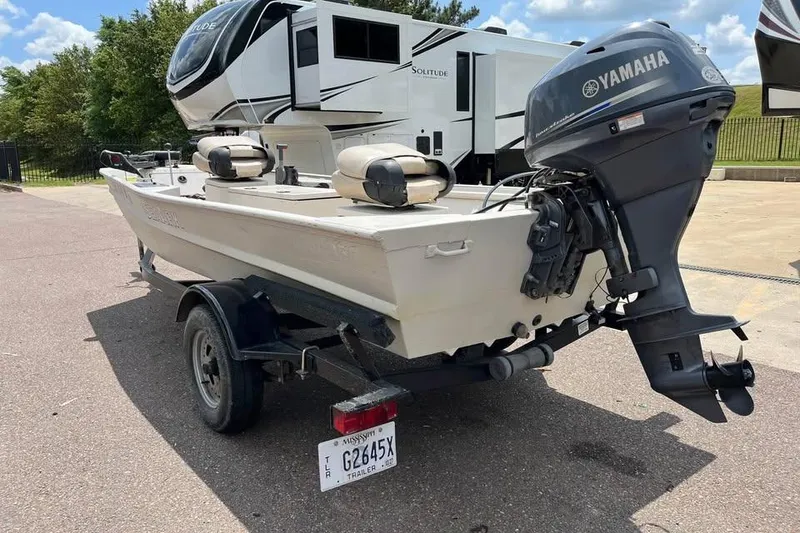 Slide: The Image of 2011 Sea-Ark Rebel 15 boat with Yamaha motor on trailer, parked near RV. - 10