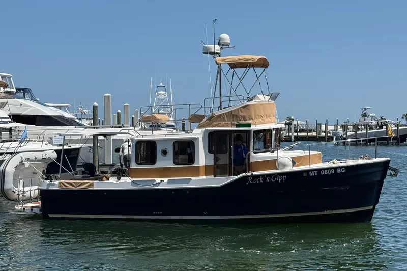 The Image of 2023 Ranger Tugs R-31 CB boat docked in a marina under clear blue skies. - 0
